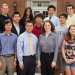 A group of students gather for a photo outside.