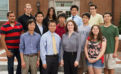 A group of students gather for a photo outside.