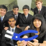 A group of students gather for a photo with their prototype.