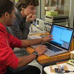 Two students work at a computer in the lab.