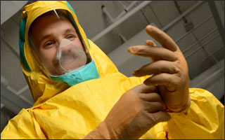 A man tries on the yellow ebola suit.