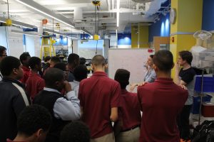 A group of boys gathers to listen to Elizabeth Logsdon.