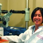 Lina Reiss sits in the lab wearing a white coat.