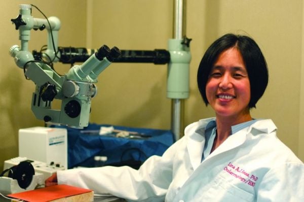 Lina Reiss sits in the lab wearing a white coat.