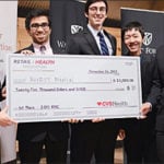 A group of students hold a giant check.