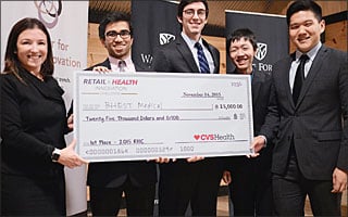 A group of students hold a giant check.