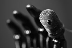 A close-up shot shows the e-dermis on the finger of a prosthetic arm.