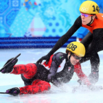 Two professional ice skaters are falling.
