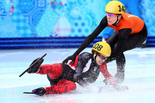 Two professional ice skaters are falling.