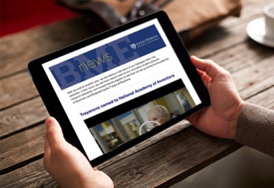An iPad shows an issue of the digital Hopkins BME newsletter.