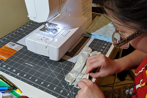 Ivy Wang is working at her sewing machine.