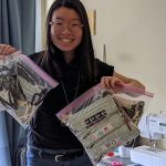 Ivy Wang is holding up two gallon bags filled with her homemade masks.