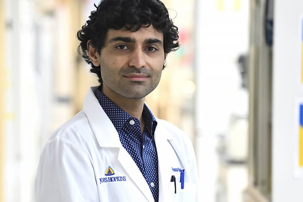 Reza Kalhor s shown in a white lab coat.