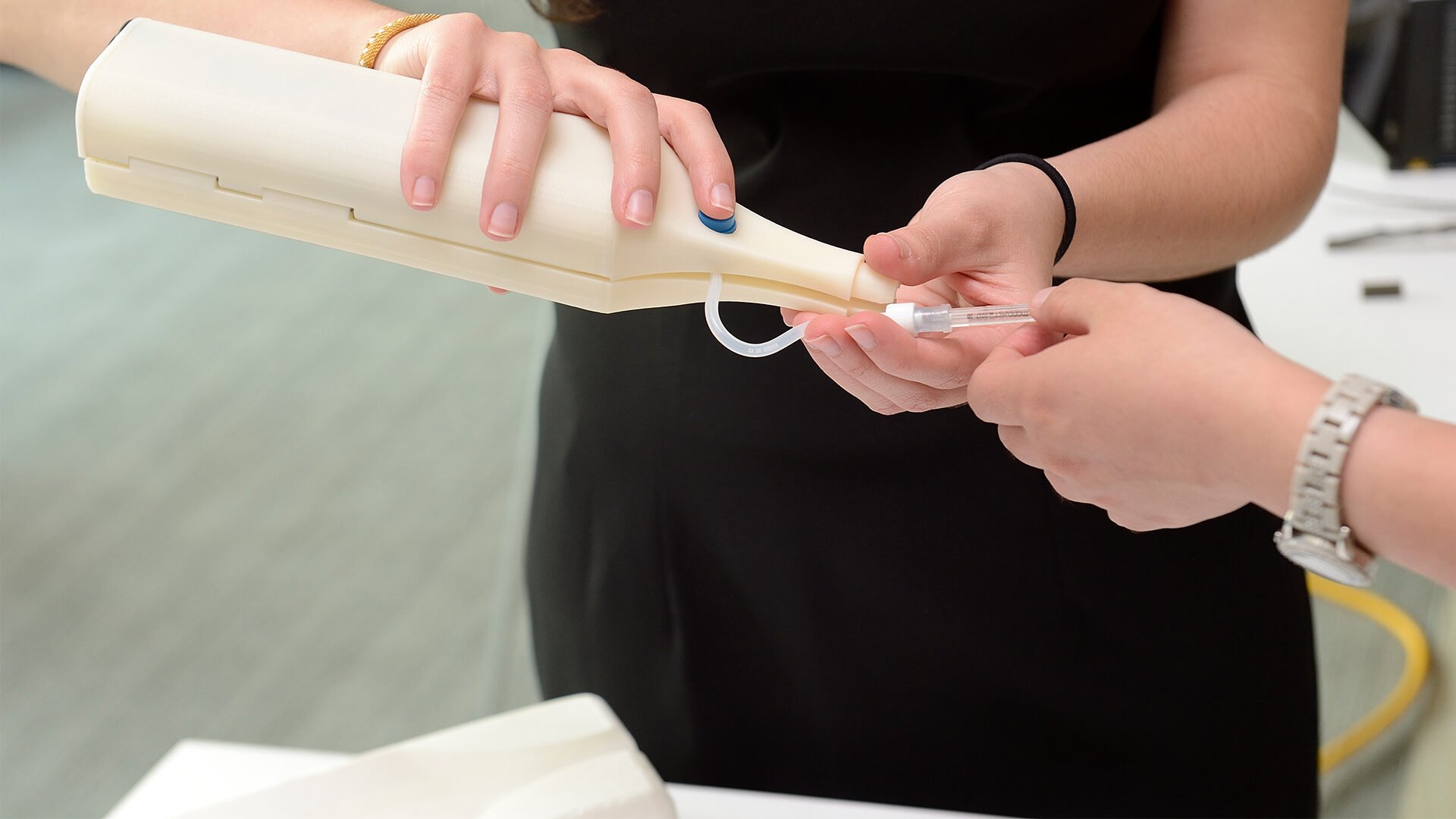 A pair of hands is holding and working with a prototype.