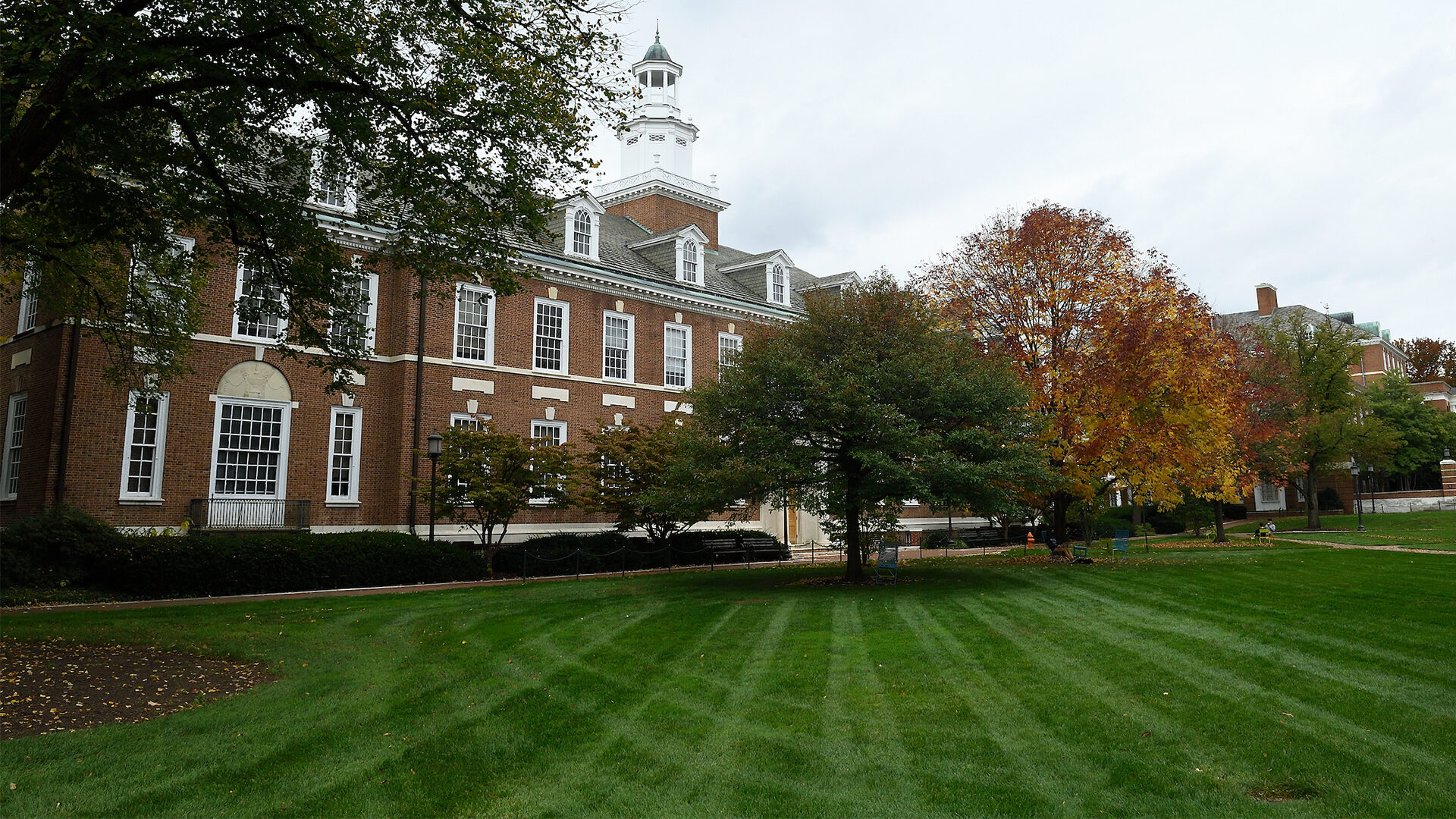 A shot of campus shows a brick building with white trim.