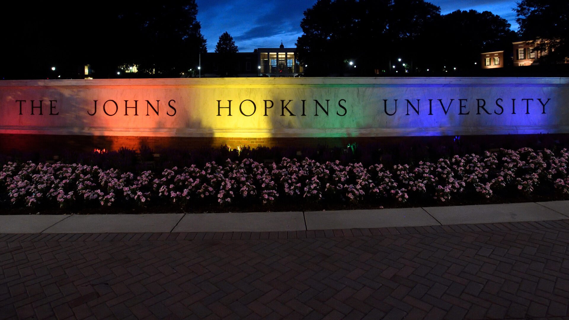 Colorful lights are shining on the Johns Hopkins University sign.