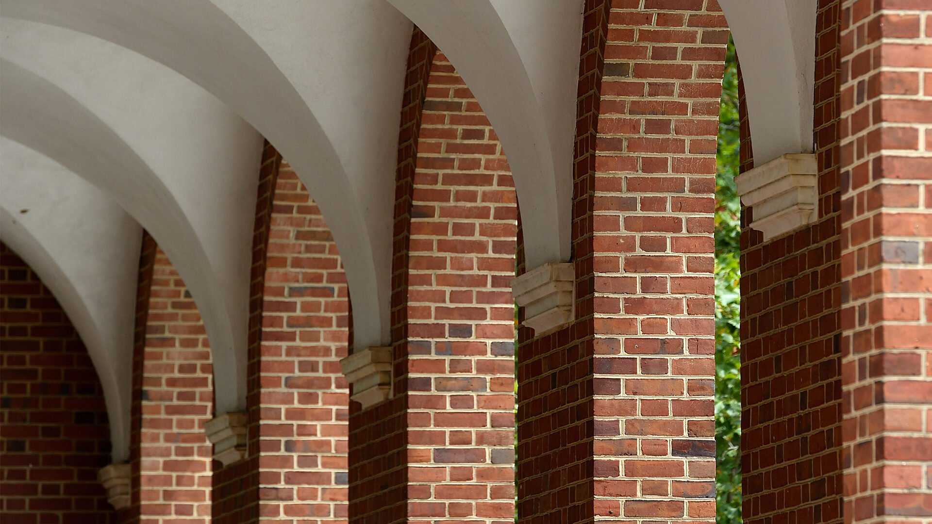 A shot on campus shows bring pillars and white arches.