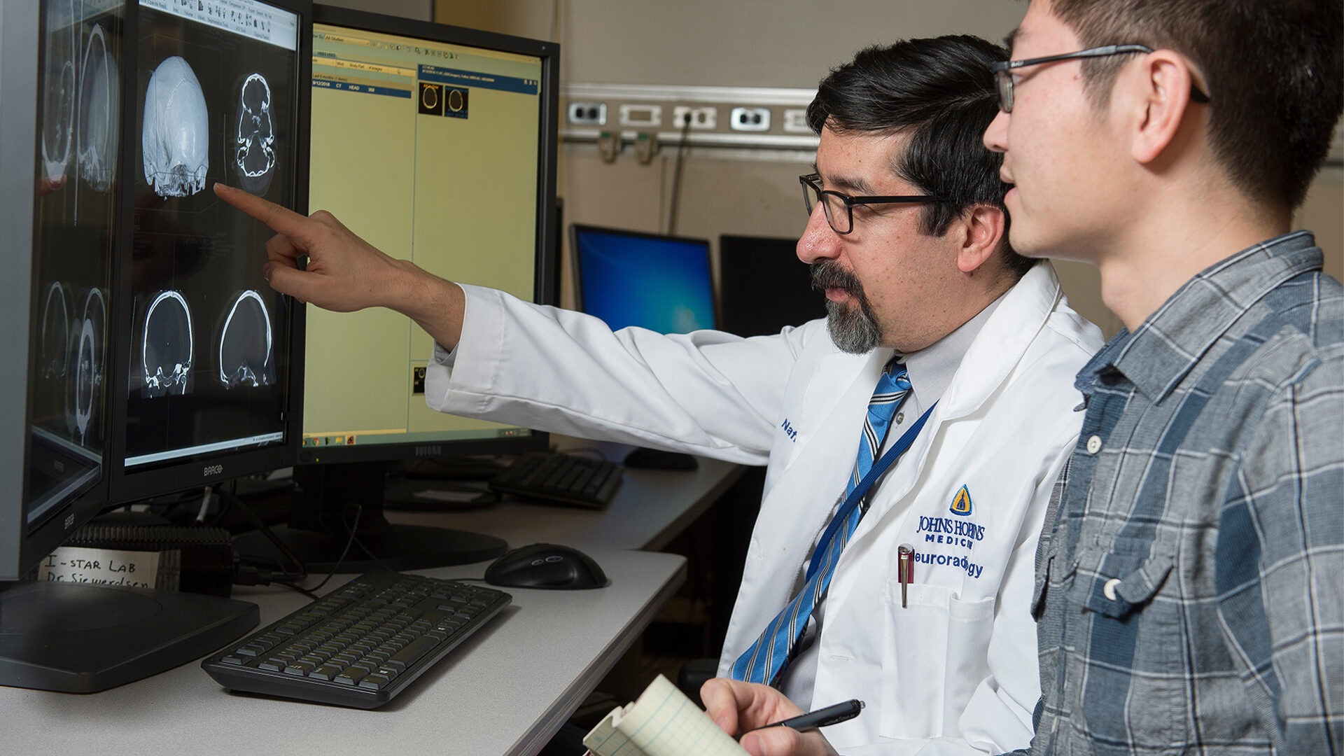 A student and clinician are working at a computer.