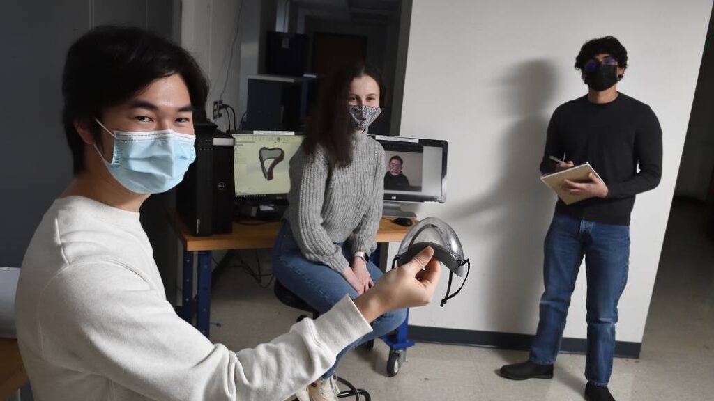 Three students of team Polair hold up the mask prototype.