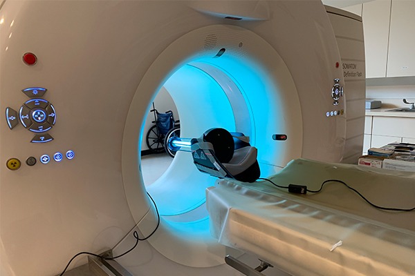 A CT scanner has a uv light shining on the inner bore.