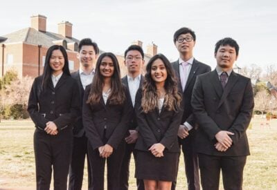 A group of students are dressed business professional and standing in a group.