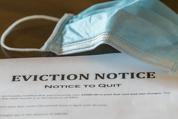 An eviction notice is shown next to a surgical mask.