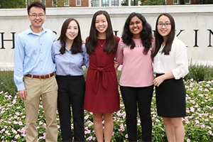 A group of people dressed professionally stand together.