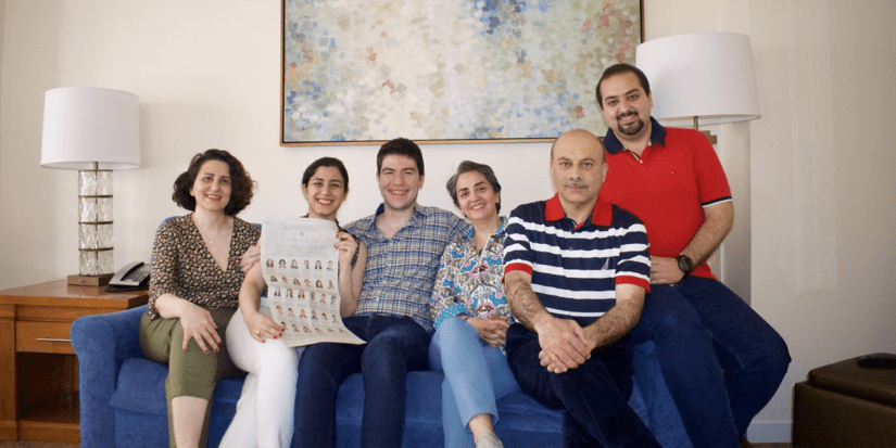 Azhir and family gather on the couch for a photo.