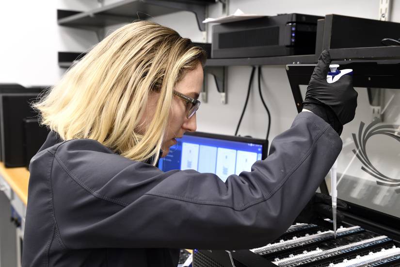 A female scientist is working with a pipette in the lab.