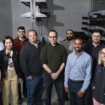 A group of scientists stand together for a photo in the lab.