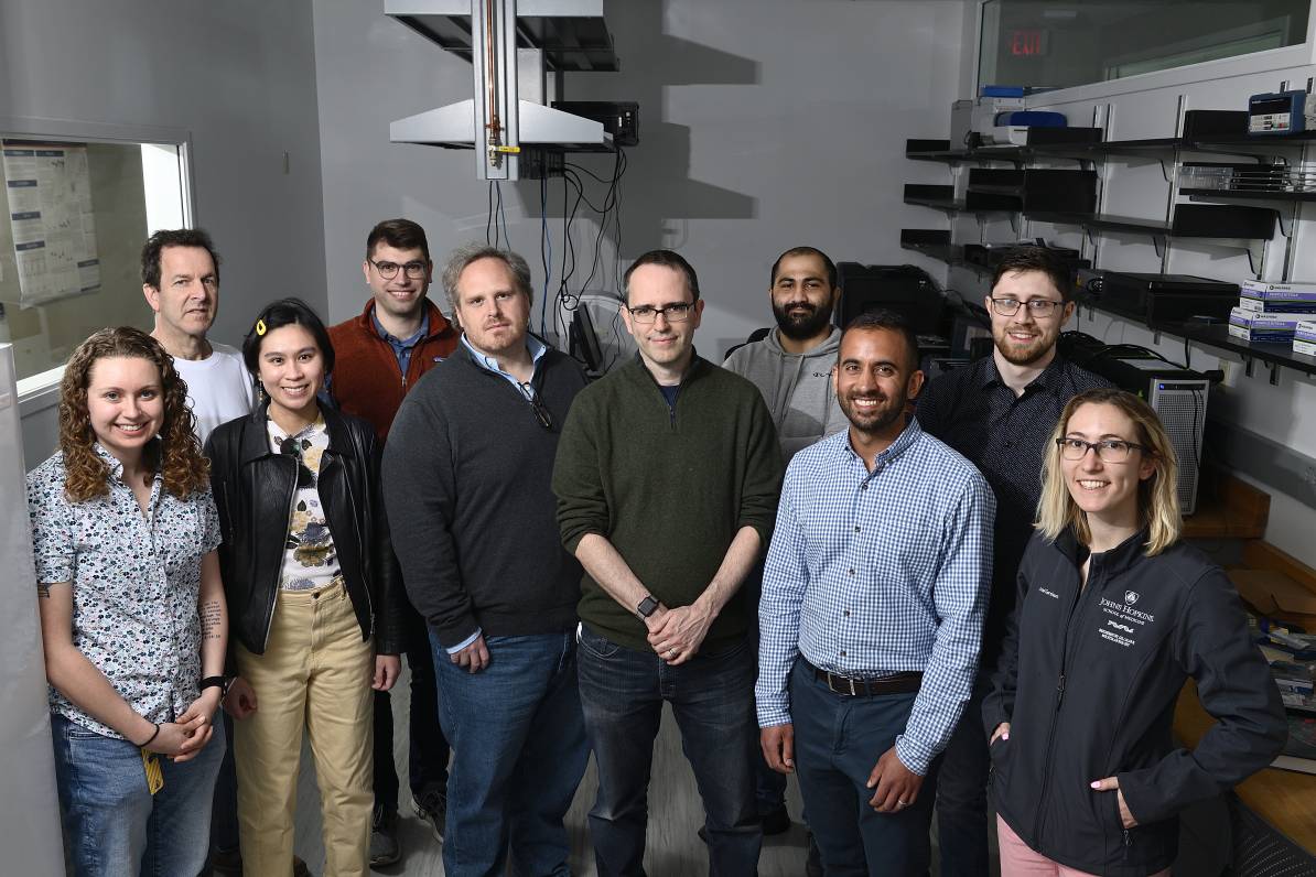 A group of scientists stand together for a photo in the lab.