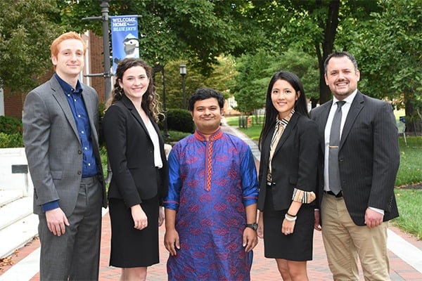 Five students stand outside for a photo.