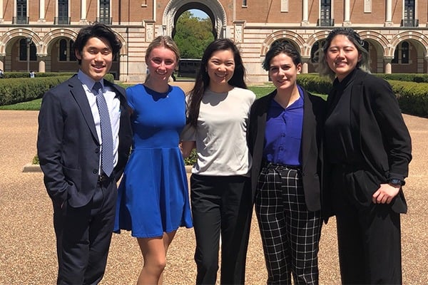 A group of students dressed in business attire are standing for a photo.