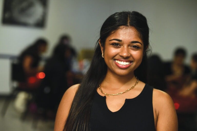 A woman is smiling to the camera.