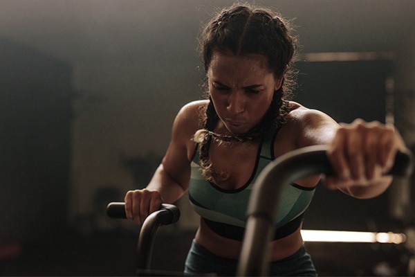 A woman is working out on a stationary bike.