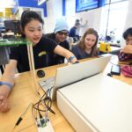 Four students are working around a table in the Design Studio.