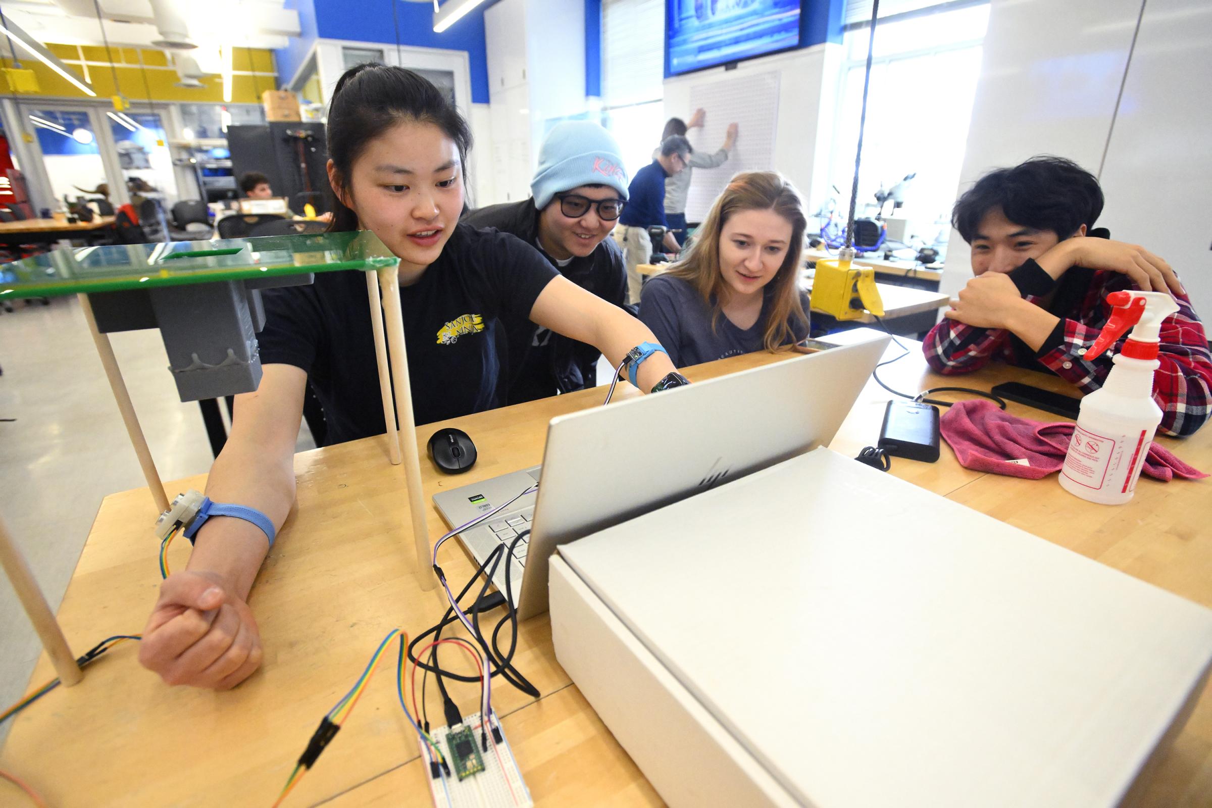 Four students are working around a table in the Design Studio.