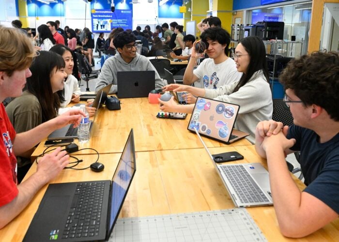 A group of students are sitting around a work table in the Design Studio.