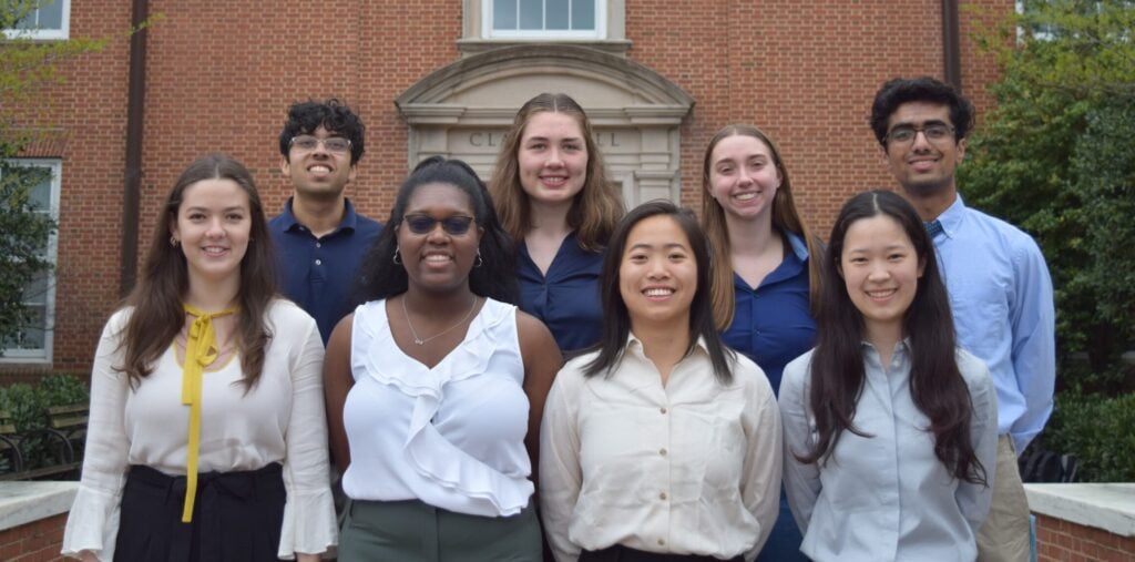 Students pose in front of academic building