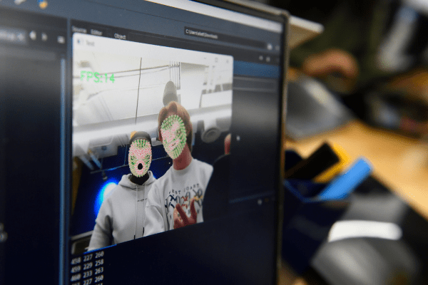 Students look at themselves on a computer screen using a software that maps their faces
