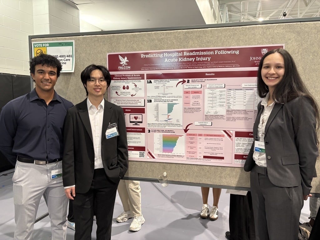 Students smile in front of their poster