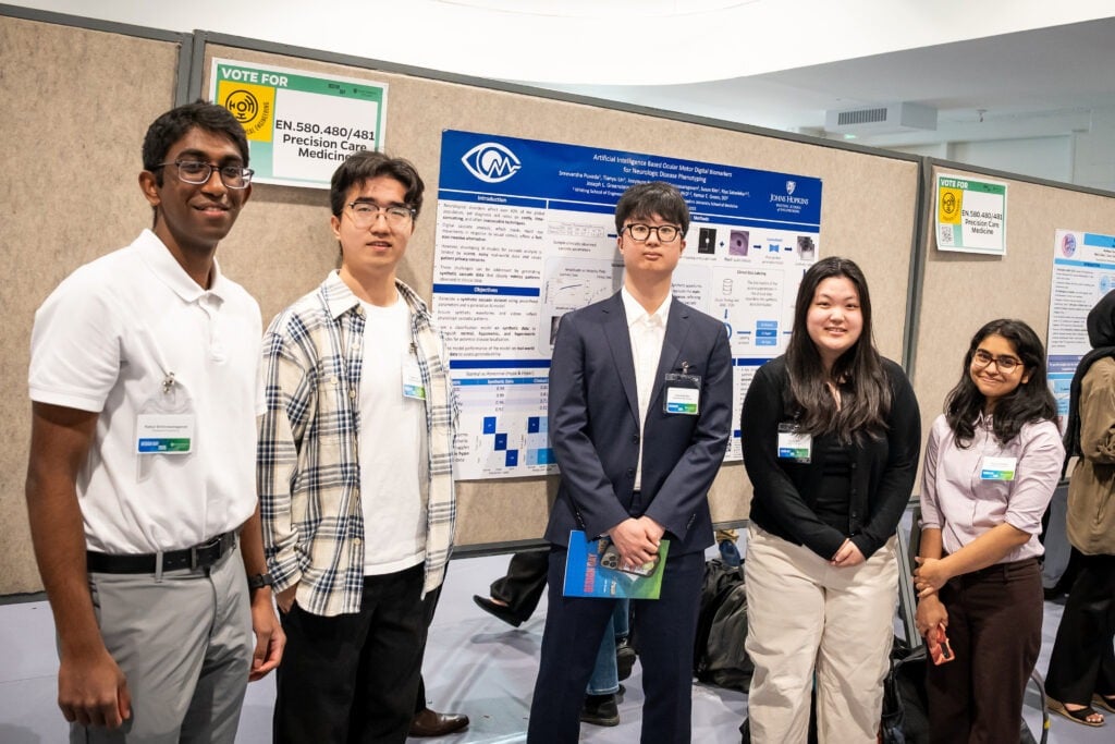 A team stands by their poster.