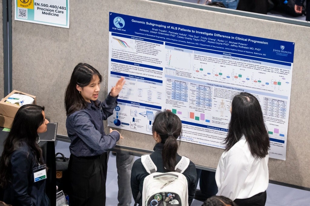Student points at poster to explain it to others