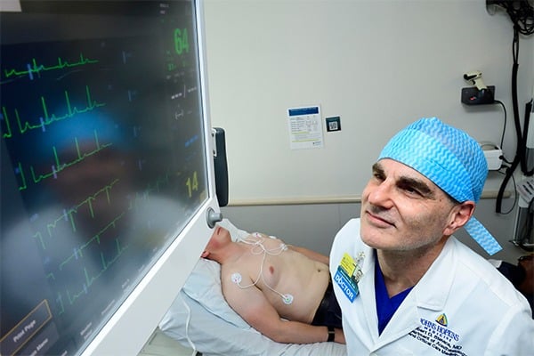 A doctor is looking up at a monitor screen.