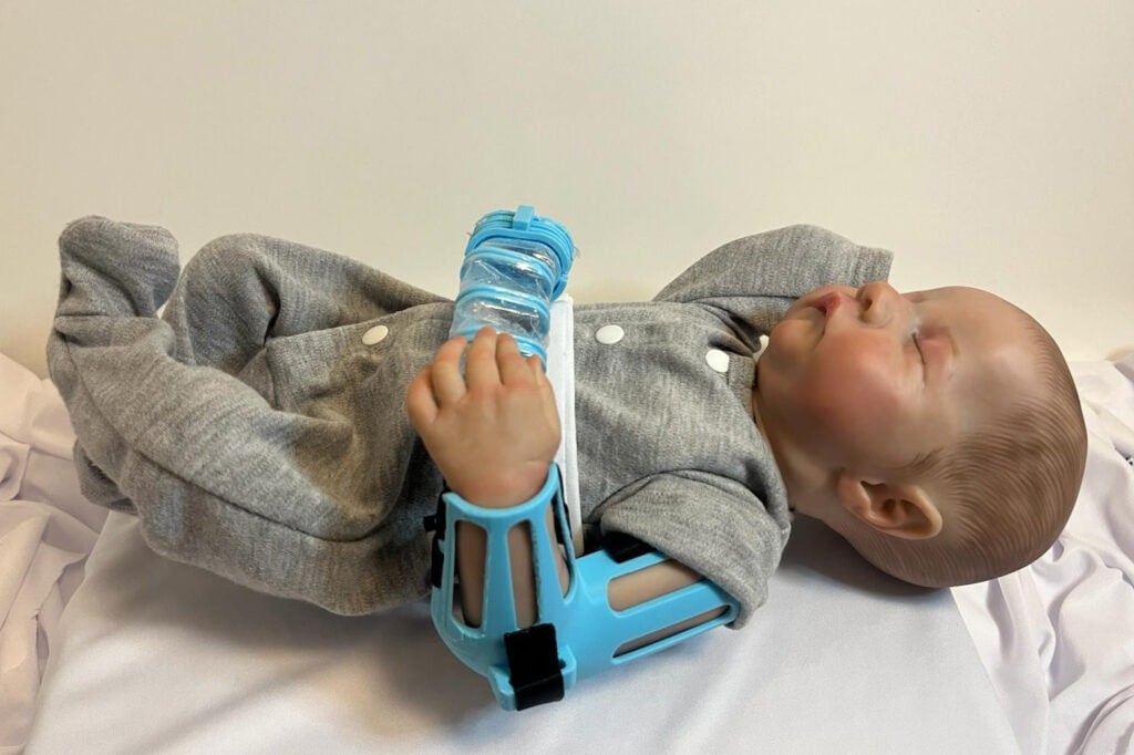 A doll demonstrates the DINA (Dynamic Infant Neurorehab Aid), a soft robotic suit designed to help rehabilitate newborns with Brachial Plexus Palsy (NBPP)