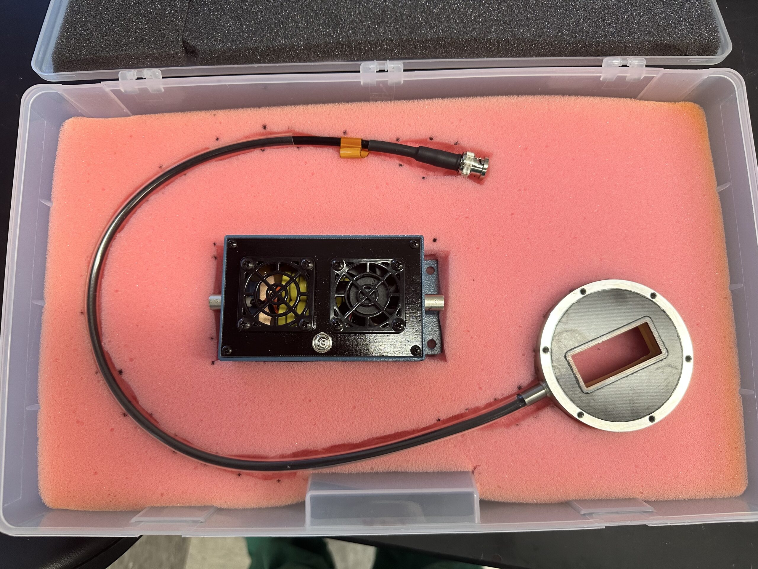FUS PROBE image Top-down view of a medical focused ultrasound system, showing a circular probe on the right and a blue frequency-matching component in the center used to tune sound waves for blood pressure regulation.